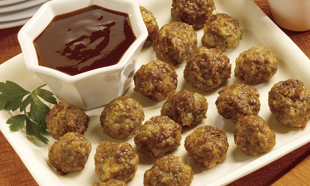 A tray of barbecue meatballs served with BBQ sauce