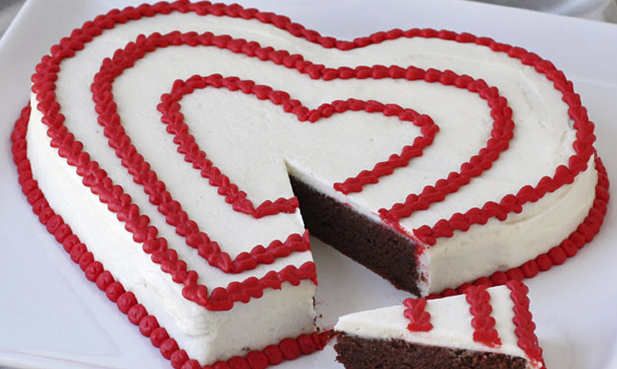 A heart-shaped chocolate potato Valentine's Day cake with a slice cut out