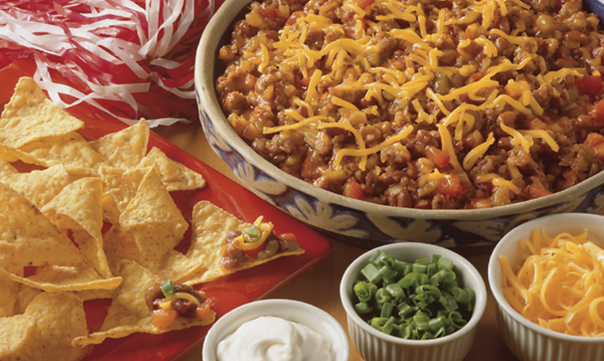 Chili dip with tortilla chips and toppings