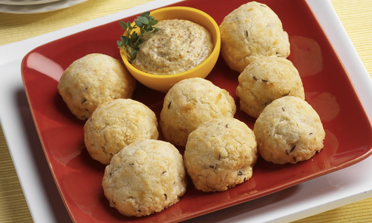 a tray of sausage sauerkraut balls with spicy mustard