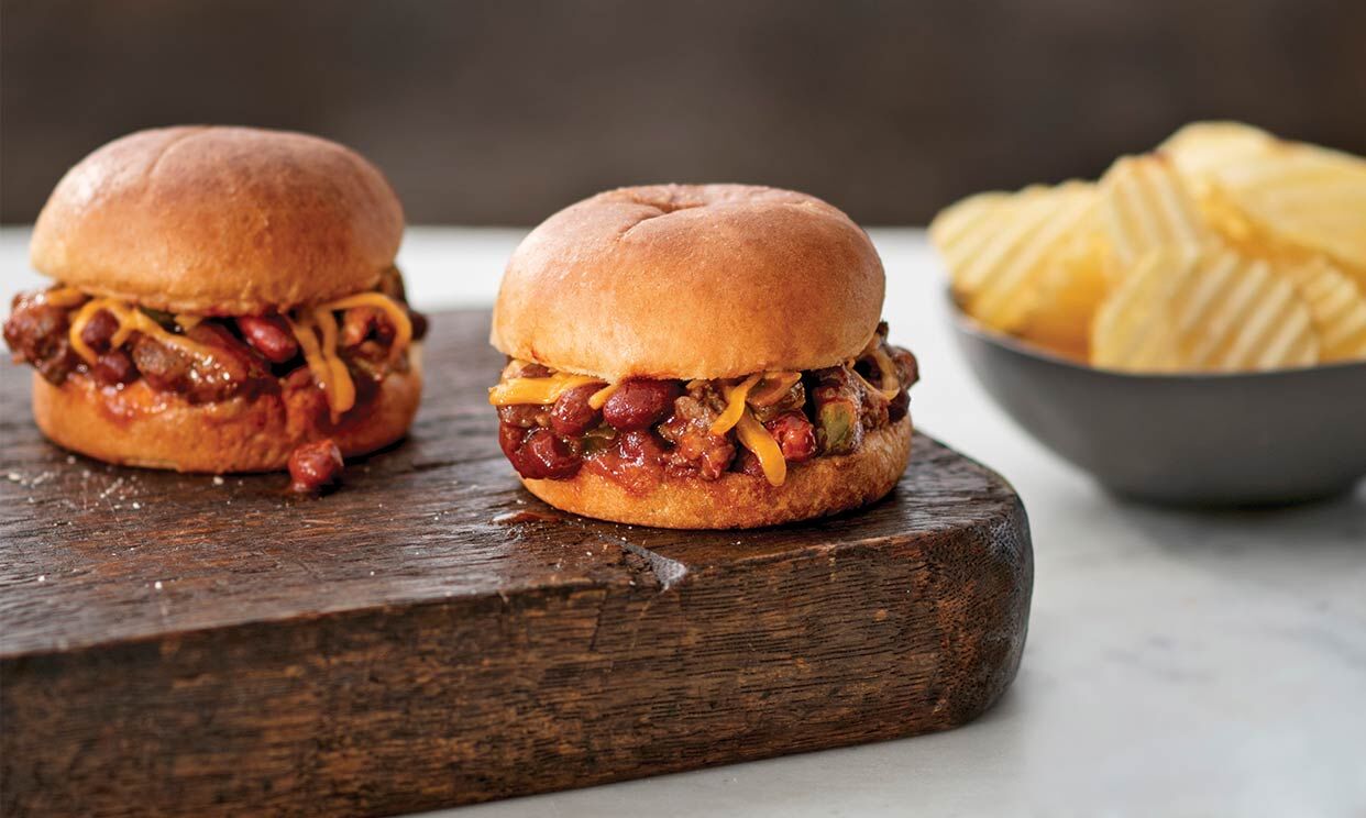 Two sausage chili sandwich sliders served with potato chips