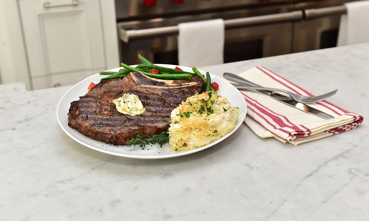 Garlic and herb mashed potato bake served with a steak and green beans