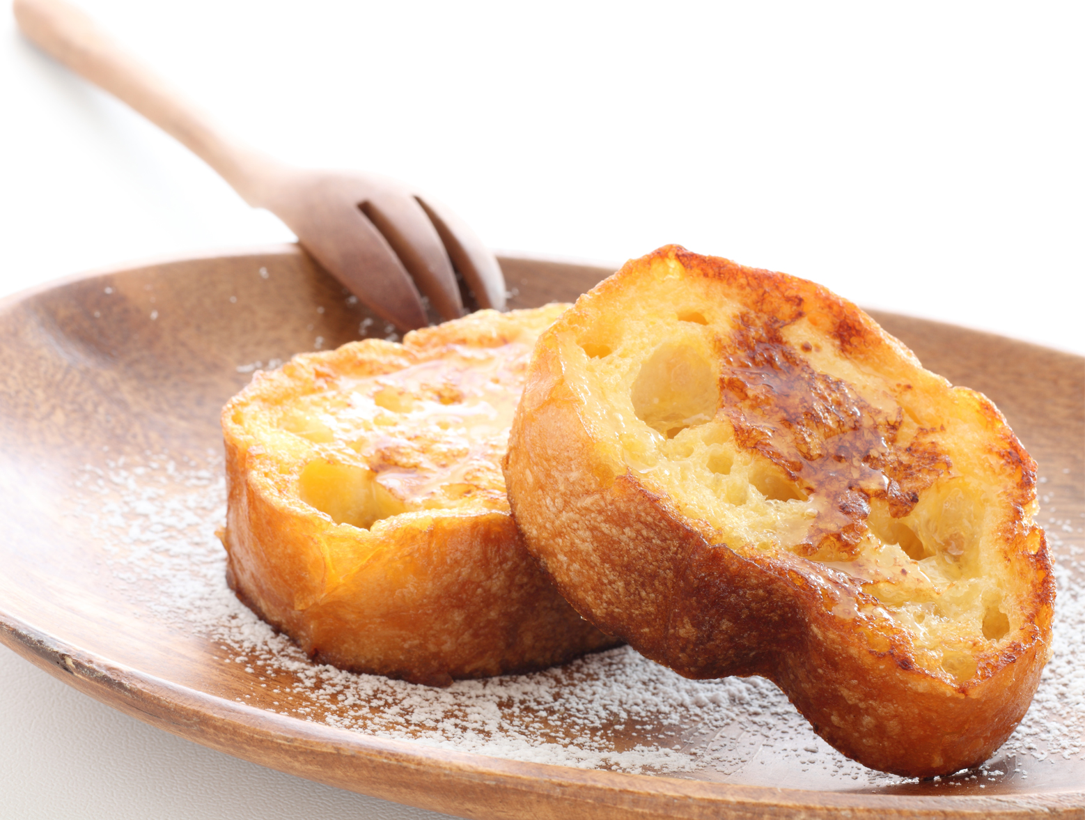 Two slices of easy egg white French toast served with powdered sugar and maple syrup