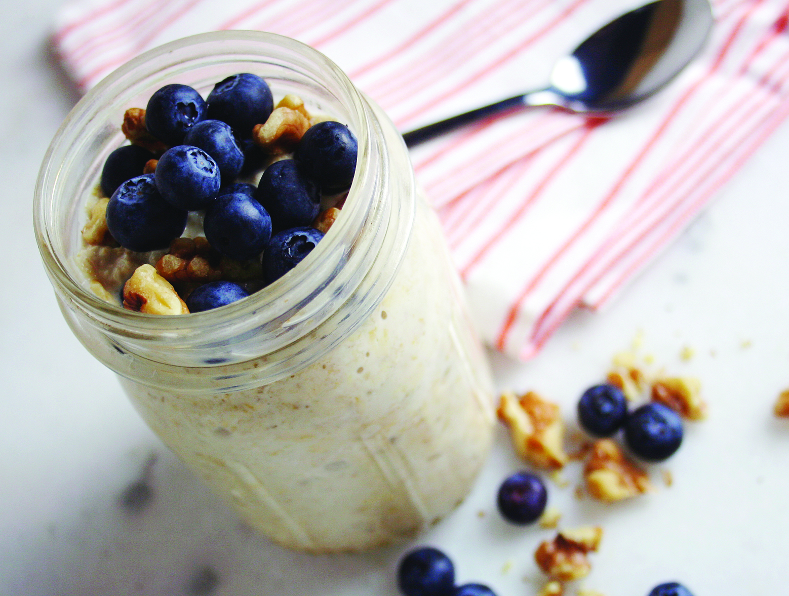 A jar of overnight oats made with egg whites and topped with blueberries