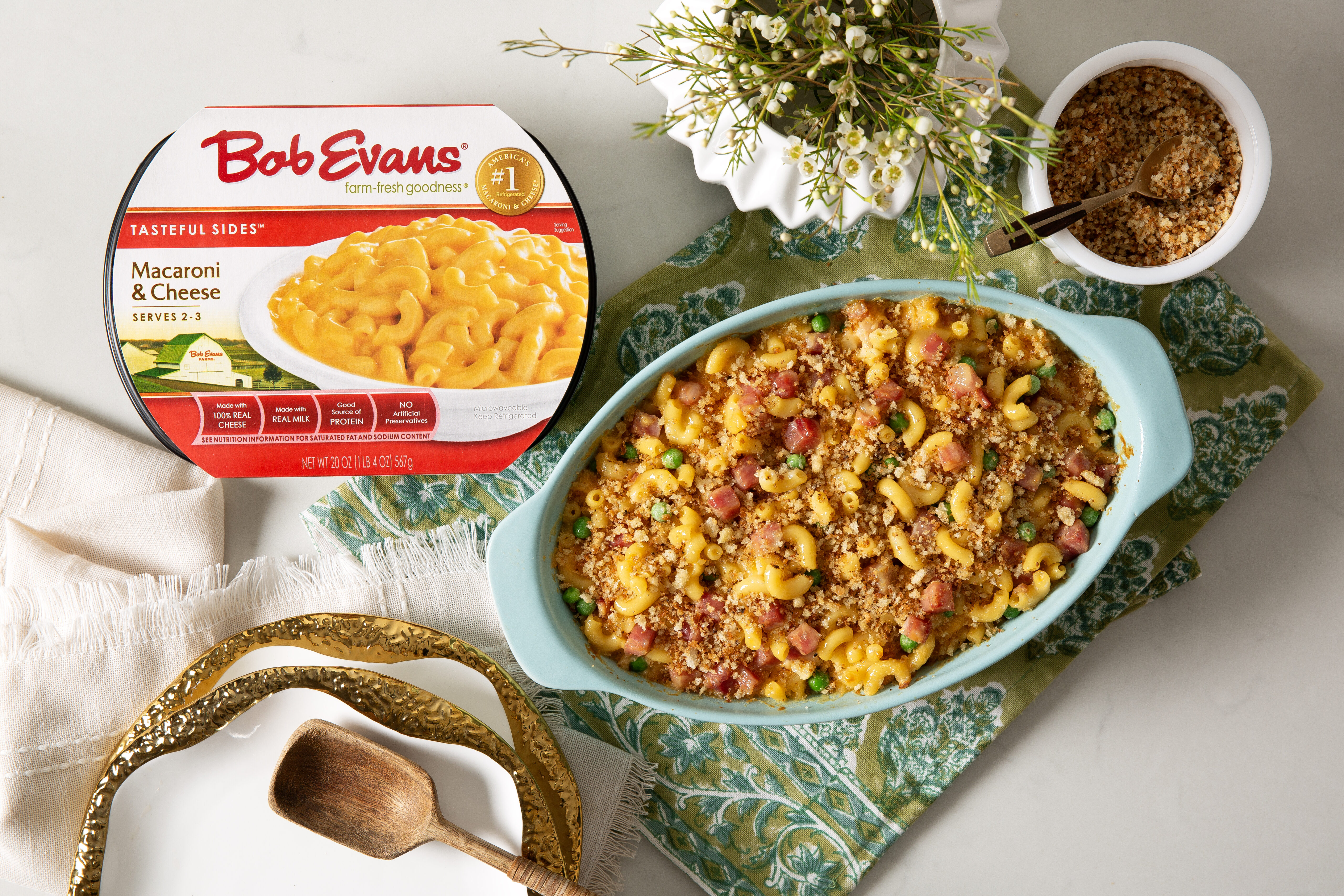 baked macaroni & cheese with peas and ham next to a package of Bob Evans Macaroni & Cheese