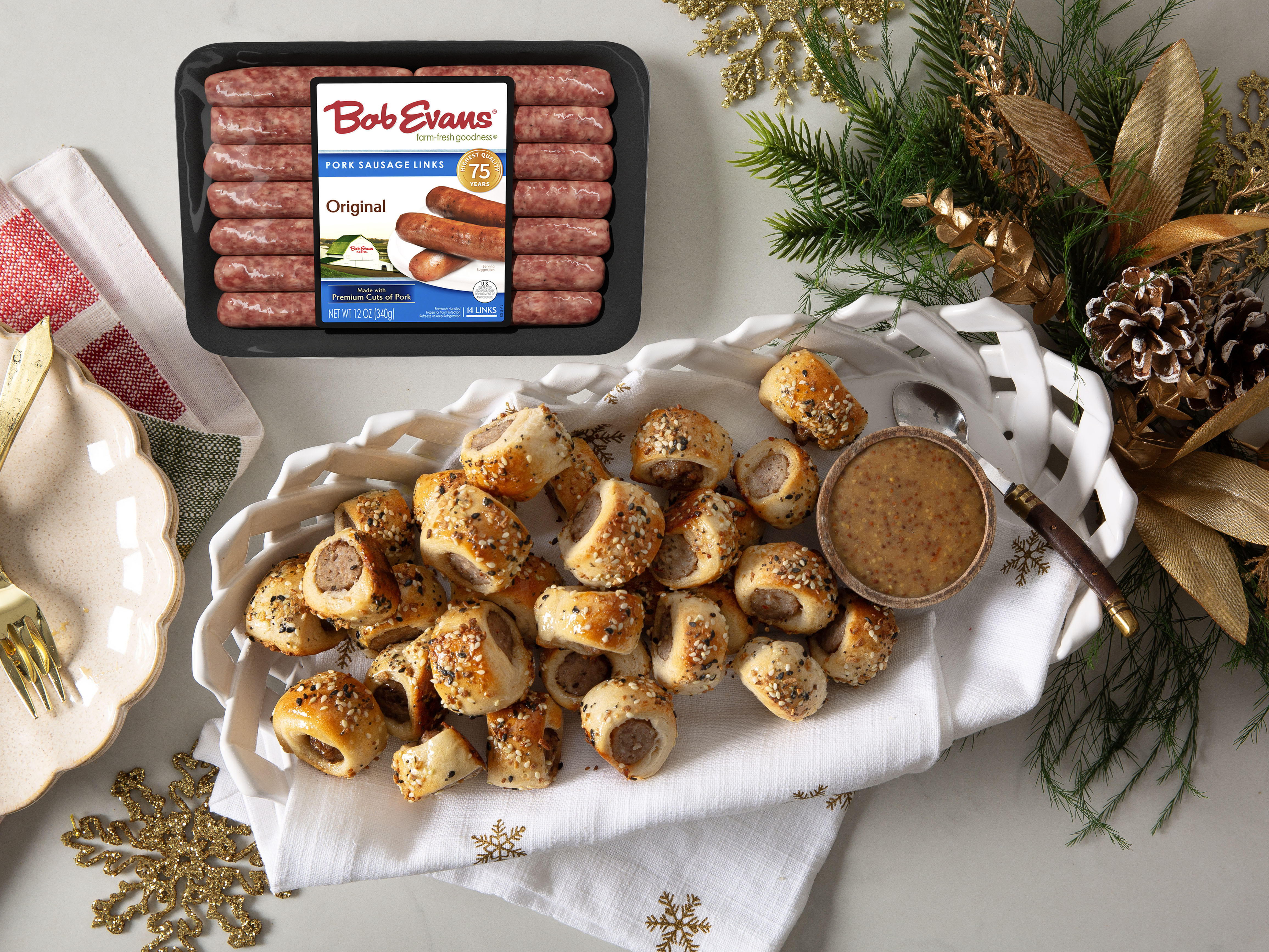 A platter of everything bagel sausage bites with honey mustard Sriracha dipping sauce next to Bob Evans Original Pork Sausage Links