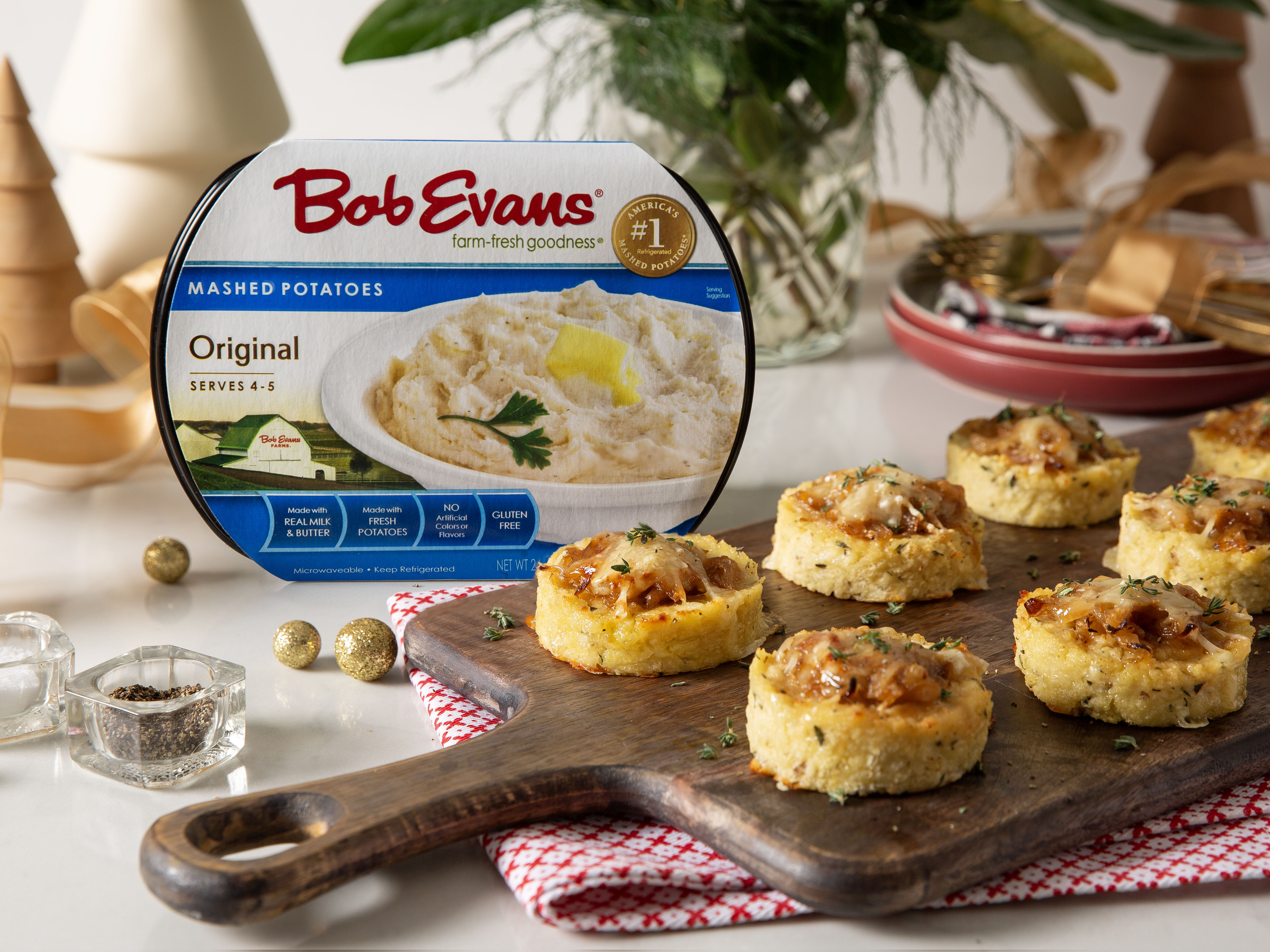 French onion mashed potato cakes on a wooden serving board next to Bob Evans Original Mashed Potatoes