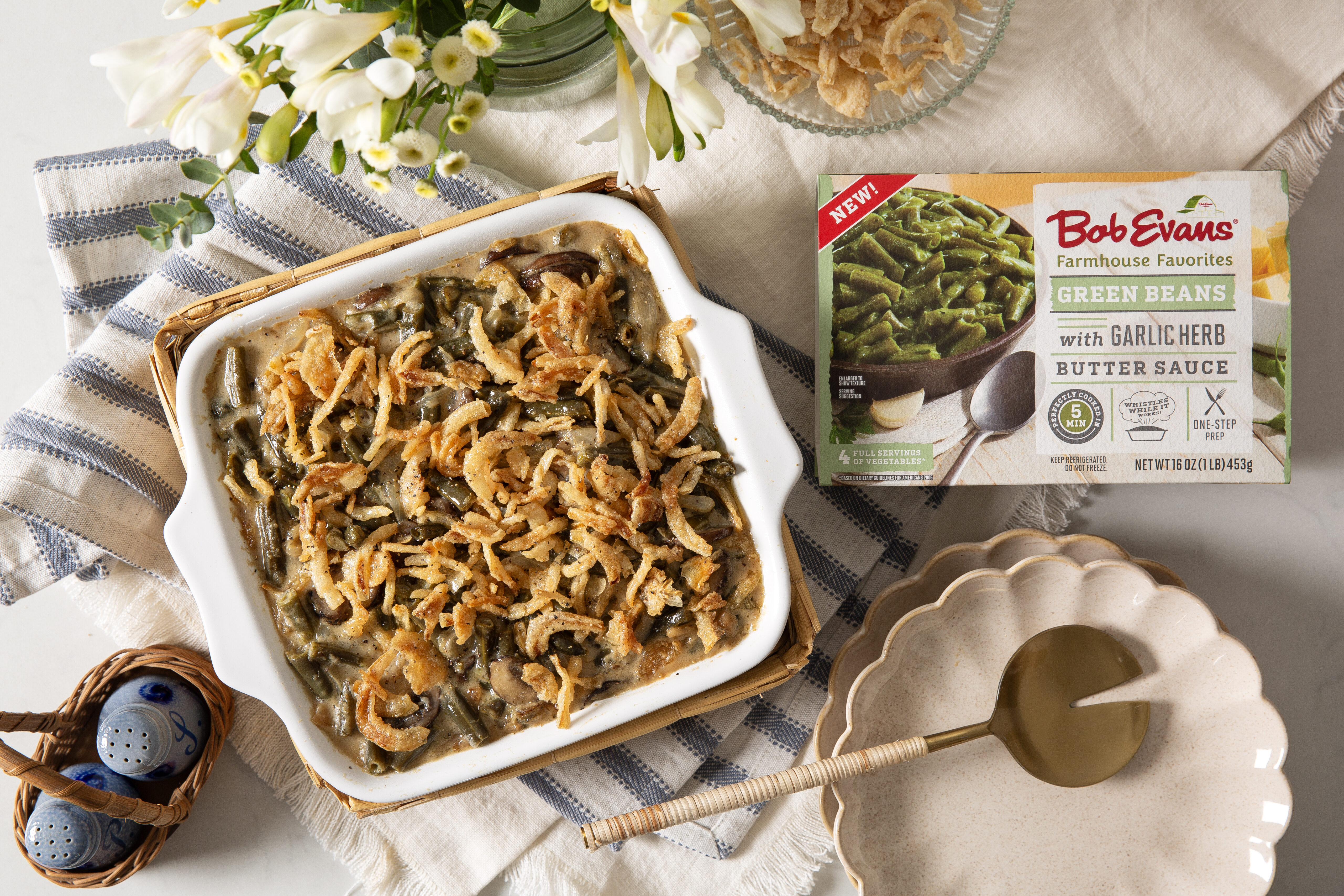 herbed green bean casserole next to a package of Bob Evans Green Beans with Garlic Herb Butter Sauce
