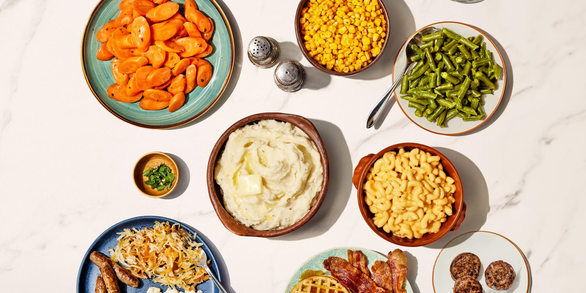 Photo of a variety of Bob Evans dishes, including sausage, bacon, carrots, mashed potatoes, corn, and green beans